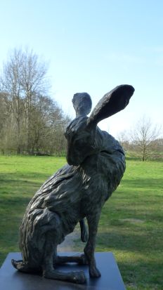 Joli-mooi is een bronzen beeld van een haas die zijn pels likt | bronzen beelden en tuinbeelden, figurative bronze sculptures van Jeanette Jansen |